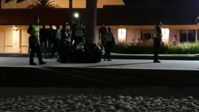 Police have arrested over a dozen people during a riot on Melbourne’s St Kilda Beach just one day after the introduction of a permanent booze ban. Footage showed police pinning suspects to the ground. Source: Channel 9