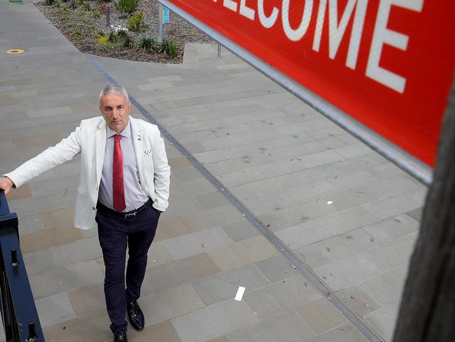 Former Cumberland City Council mayor Steve Christou pictured under a anti racism sign that was recently erected outside the Ashfield Aquatic Centre. Picture: Toby Zerna