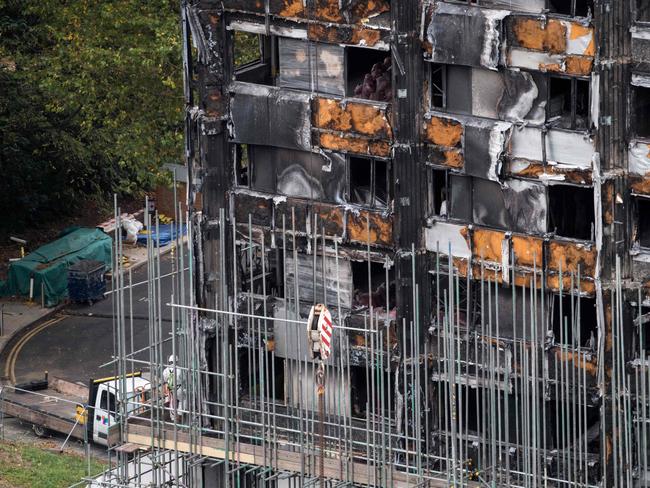 Scaffolding is seen with coverings at the base of the burned-out-shell of Grenfell Tower in London on October 17, 2017 as investigations continue into the tragedy.  An inquiry into the Grenfell Tower fire disaster opened last month as survivors demanded answers over the west London apartment block blaze that killed at least 80 people on June 14. Scaffolding started to be errected around the burnt shell of the building with investigators continuing their investigations into the deadly fire. / AFP PHOTO / CHRIS J RATCLIFFE