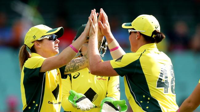 Sarah Coyte and Grace Harris celebrate a wicket for Australia.