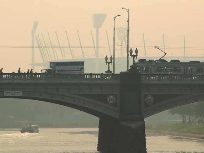 15/01/2020: A tram goes over Princes Bridge with the MCG in the background as smoke haze continues to clog the city, forcing commuters to wear face masks to avoid breathing it in. Stuart McEvoy/The Australian.