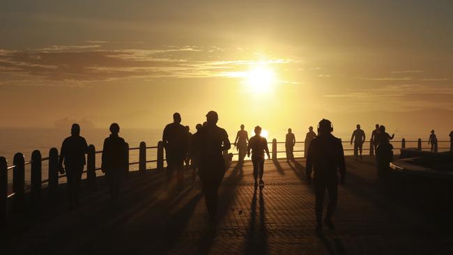 People exercise along the promenade at sunrise in Sea Point, Cape Town, South Africa, last week. Picture: AP