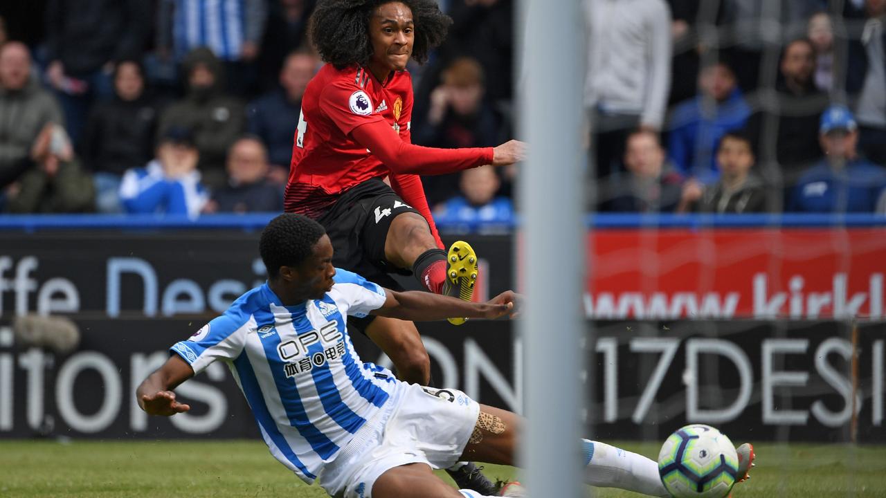 Manchester United's Dutch midfielder Tahith Chong shoots wide as Huddersfield Town's Swiss-born Dutch defender Terence Kongolo tries to block during the English Premier League football match between Huddersfield Town and Manchester United at the John Smith's stadium in Huddersfield, northern England on May 5, 2019. - Manchester United fail to qualify for the Champions League after 1-1 draw at Huddersfield. (Photo by Paul ELLIS / AFP) / RESTRICTED TO EDITORIAL USE. No use with unauthorized audio, video, data, fixture lists, club/league logos or 'live' services. Online in-match use limited to 120 images. An additional 40 images may be used in extra time. No video emulation. Social media in-match use limited to 120 images. An additional 40 images may be used in extra time. No use in betting publications, games or single club/league/player publications. /