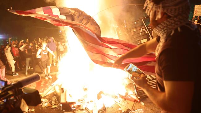 Protesters burn a US flag in a bonfire during a rally against the death in Minneapolis police custody of George Floyd in Washington DC.