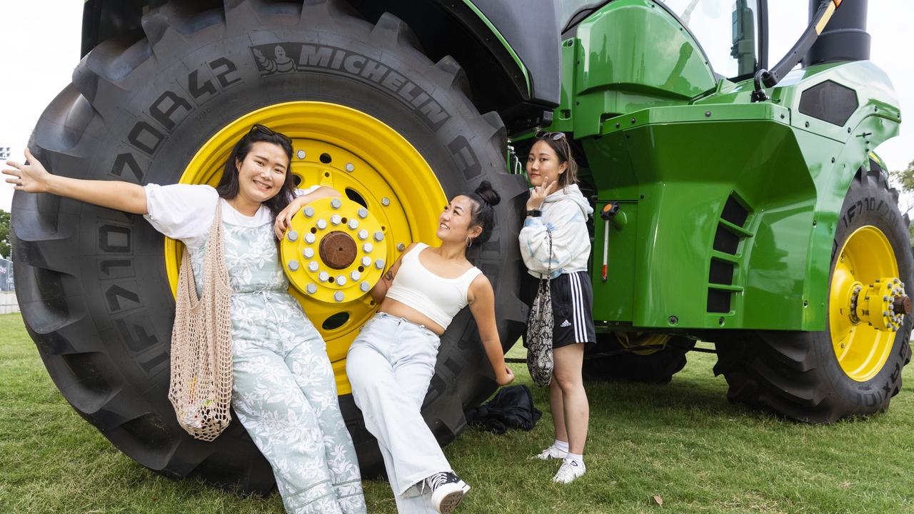 USQ students (from left) Mihwa Jeon, Minseo Jung and Hyunsu Kim with a tractor at the 2022 Toowoomba Royal Show, Friday, March 25, 2022. Picture: Kevin Farmer