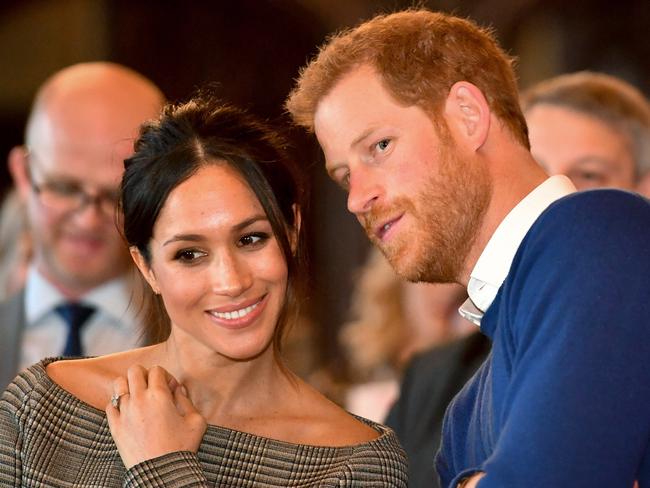 CARDIFF, WALES - JANUARY 18:  Prince Harry whispers to Meghan Markle as they watch a dance performance by Jukebox Collective in the banqueting hall during a visit to Cardiff Castle on January 18, 2018 in Cardiff, Wales. (Photo by Ben Birchall - WPA Pool / Getty Images)