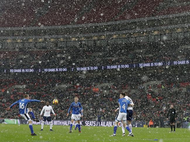 Rochdale’s Matt Done, left, clears the ball as snow falls during the English FA Cup fifth round replay soccer match between Tottenham Hotspur and Rochdale at Wembley stadium in London, Wednesday, Feb. 28, 2018. Picture: AP