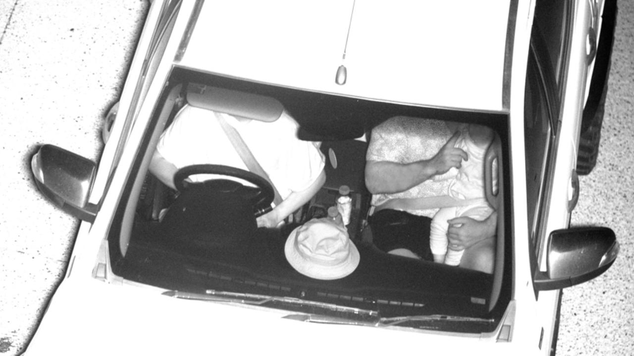 An image of a person with a child in their arms while a front-seat passenger.