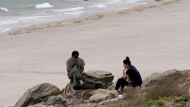 Family and friends await updates as emergency services crews scour the beach and ocean in the search for missing carer Nischal Ghimire, who disappeared while looking after a young boy. Picture: KELLY BARNES/AAP