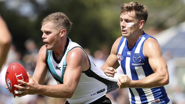 Port Adelaide’s Dan Houston is held back by North Melbourne’s Shaun Higgins in a JLT game. Picture: Sarah Reed