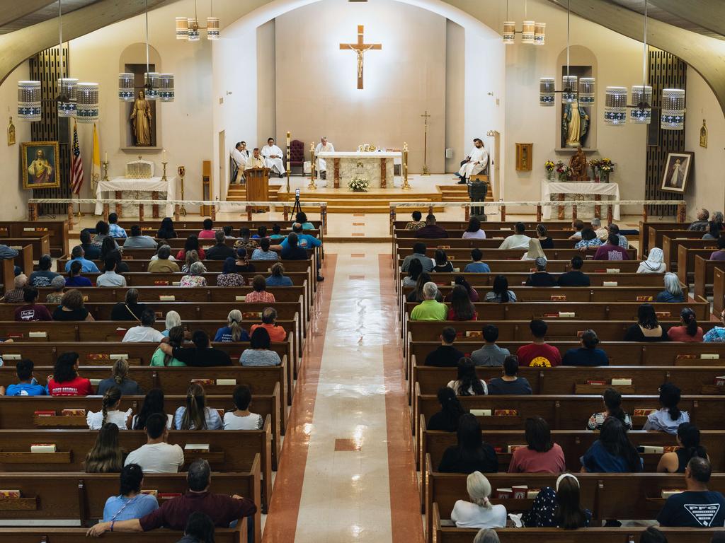 Mourners attend a vigil at Sacred Heart Catholic Church for victims of the mass shooting.