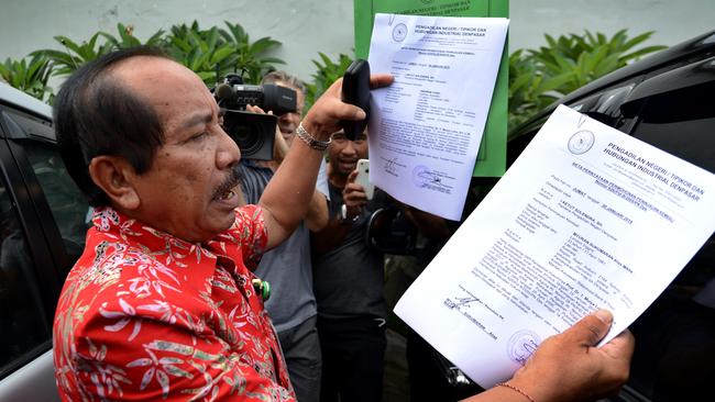 A district court registrar in Denpasar displays the applications filed yesterday on behalf of death-row convicts Andrew Chan and Myuran Sukumaran. Picture: Nashyo Hansel