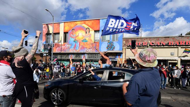 Pelple cheer from their car celebrating Joe Biden’s victory ahead of his address. Picture: AFP.