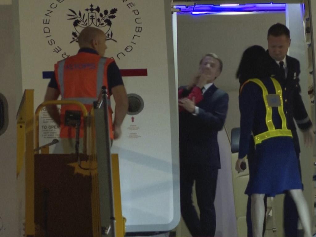 The wife of French President Emmanuel Macron shoves him in the face in an unguarded moment as they prepares to disembark a plane on arrival in Hanoi, Vietnam. Picture: AP