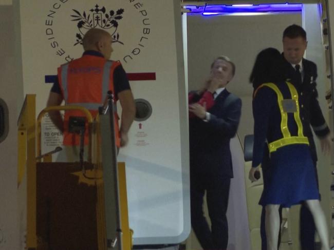 The wife of French President Emmanuel Macron shoves him in the face in an unguarded moment as they prepares to disembark a plane on arrival in Hanoi, Vietnam. Picture: AP