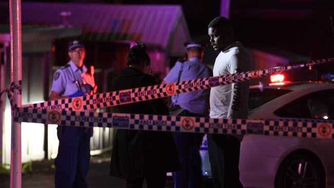 A man looks on as police seal off the shooting scene last night Picture: Gordon McComiskie