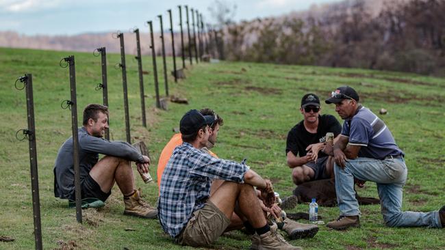 Hawthorn listen to the story of a local farmer as they prepare to rebuild his fence. Picture: Matt McLeish.