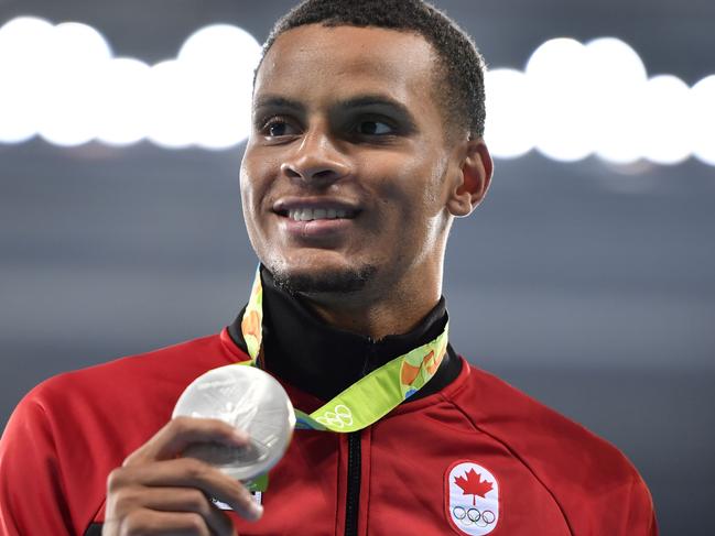 (LtoR) Canada's Andre de Grasse (silver medal) poses during the podium ceremony for the Men's 200m during the athletics event at the Rio 2016 Olympic Games at the Olympic Stadium in Rio de Janeiro on August 19, 2016.   / AFP PHOTO / Fabrice COFFRINI