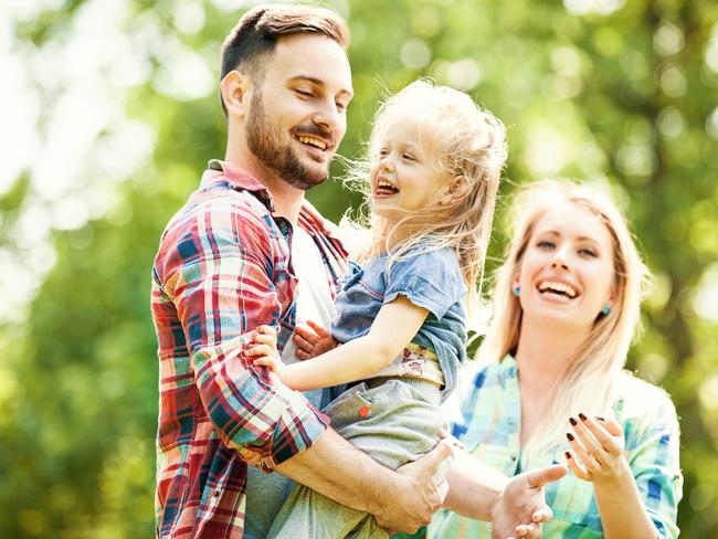 Happy family of three enjoying sunny day in the park; life insurance generic mum dad and child