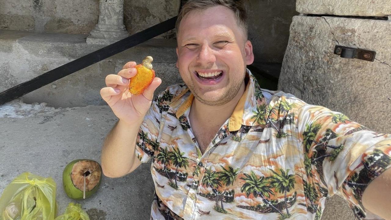 Thomas with the cashew apple which burned his face. Picture: SWNS.