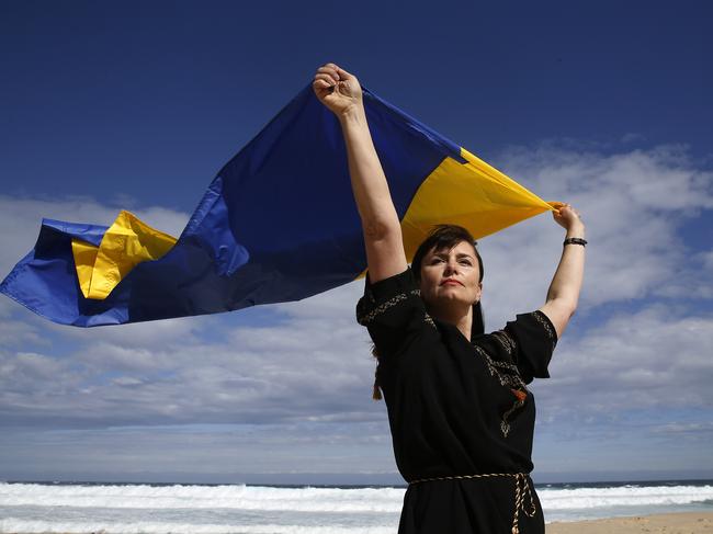 WENTWORTH COURIER ONLY. SEE EDITOR TIM MCINTYRE FOR PERMISSION TO USE. Ukrainian Support Caseworker/Project Officer at the Ukrainian Council of NSW Natalia Borodina flying the Ukraine flag on Bronte Beach where she helps facillitate  a learn to swim program out of Bronte Surf Club. PIcture: John Appleyard