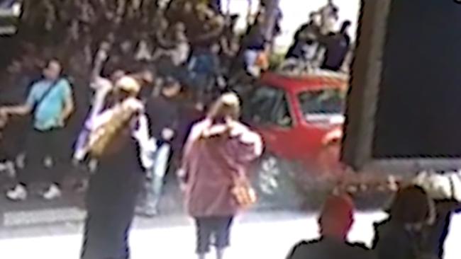 The car mounts the footpath on Swanston Street.