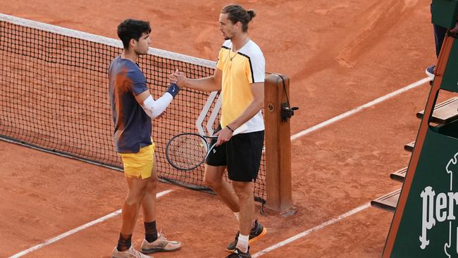 Spain's Carlos Alcaraz (L) shakes hands with Germany's Alexander Zverev after winning at the end of their men's singles final match on Court Philippe-Chatrier on day fifteen of the French Open tennis tournament at the Roland Garros Complex in Paris on June 9, 2024. (Photo by Dimitar DILKOFF / AFP)