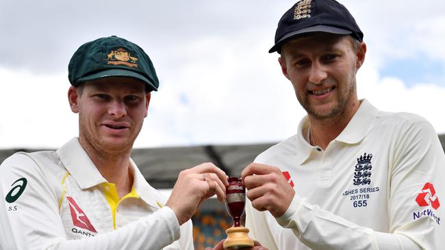 Australia's skipper Steve Smith (L) and England captain Joe Root hold a replica Ashes Urn as they pose at a media opportunity in Brisbane on November 22, 2017, ahead of the first Test of the Ashes Series. / AFP PHOTO / SAEED KHAN / IMAGE RESTRICTED TO EDITORIAL USE - STRICTLY NO COMMERCIAL USE