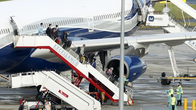 Passengers in face masks step off the chartered Airbus. Picture: Getty