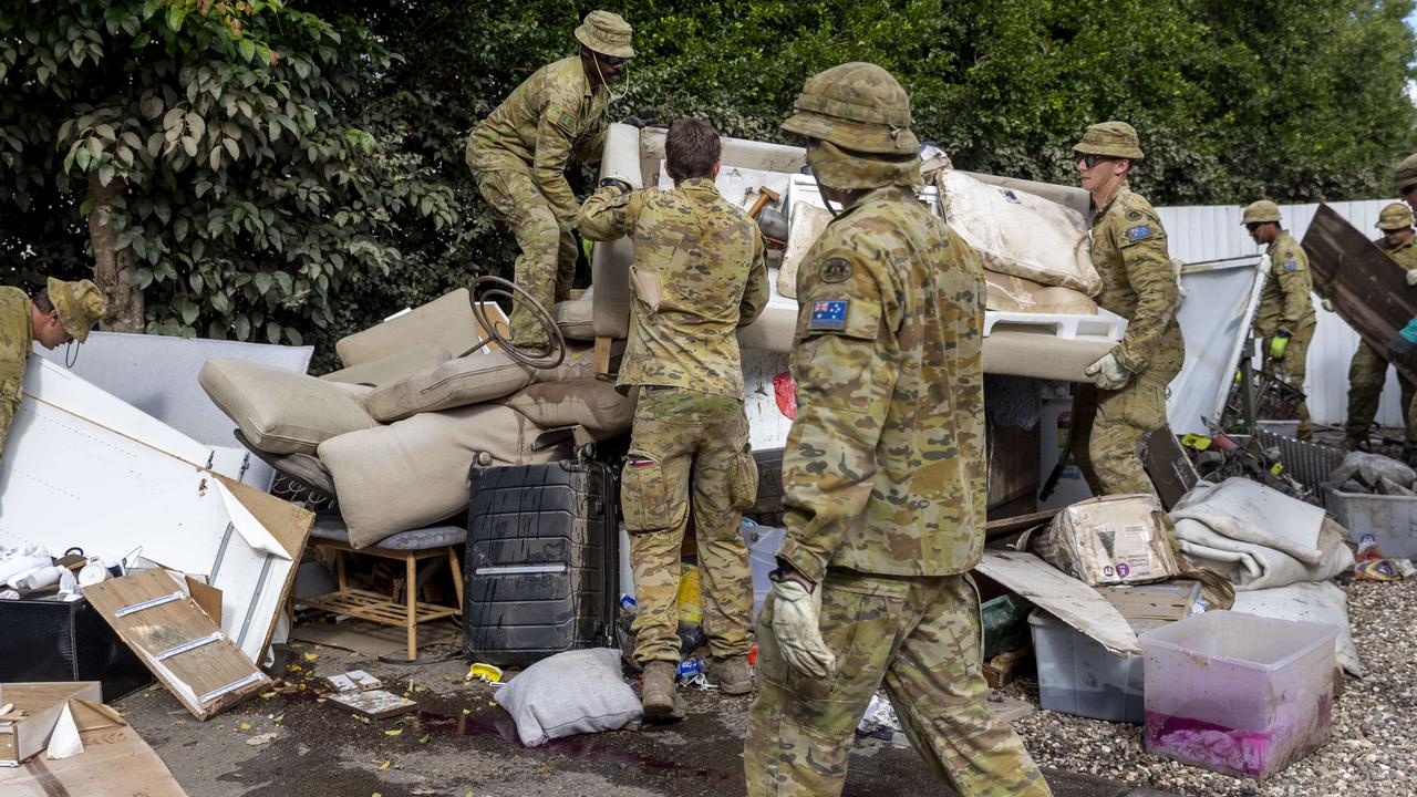 The Army cleans up household waste around the streets of Milton. They have been brought in to help with the clean-up in flood affected areas of Queensland. Picture: NewsWire / Sarah Marshall