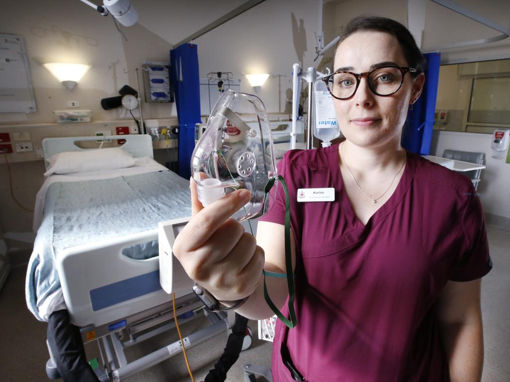 Frontline COVID-19 nurse specialist Karlee Robson with a mask to pump humidified oxygen into a patient’s lungs. Picture: David Caird