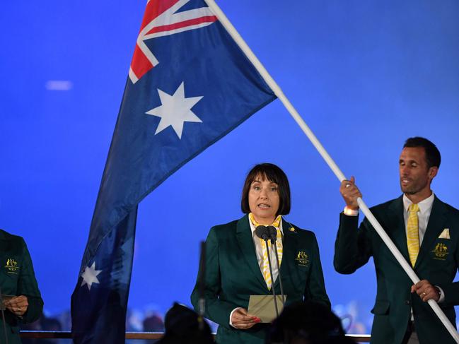 Australia's lawn bowler Karen Murphy (L) and netball coach Lisa Alexander (C) take an oath beside Australia's flagbearer Mark Knowles during the opening ceremony of the 2018 Gold Coast Commonwealth Games at the Carrara Stadium on the Gold Coast on April 4, 2018. / AFP PHOTO / WILLIAM WEST