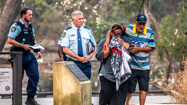 A couple walks with police from the lake’s edge. Picture: Monique Harmer