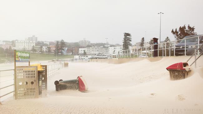Bondi’s beach sand blanketed most of its world famous sidewalk as a result of the weather. Picture: Julia Wheeler