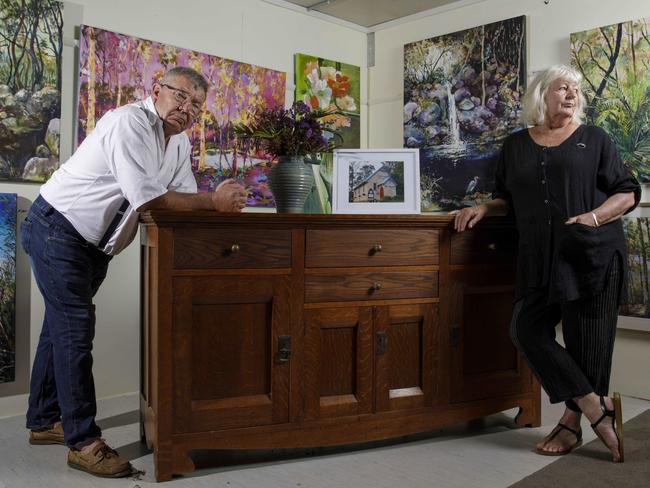 Mogo residents and owners of Mogo Pottery Peter and Vanessa Williams lost their home and pottery gallery on 31 December 2019. They are planning to rebuild the gallery in the same spot and have taken up painting again over the past 10 months and have set up a small painting gallery in Mogo. The couple are pictured with an antique sideboard that they saved from their home on the day of the fire. Picture by Sean Davey.