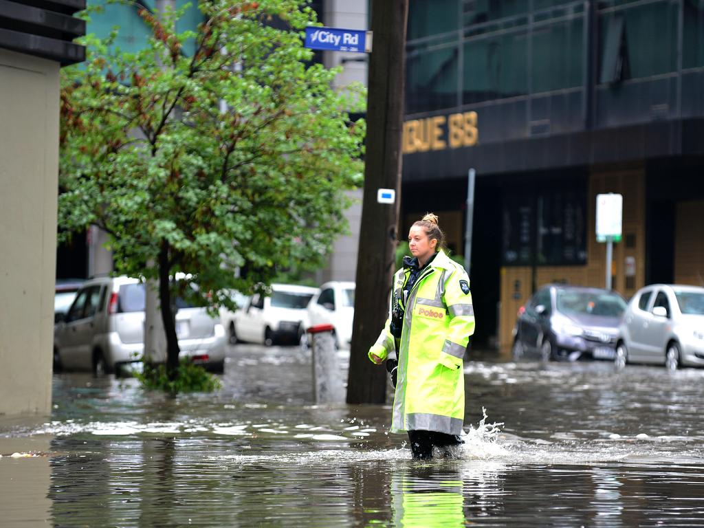 A police officer up to her ankles in floodwaters at Melbourne’s Southbank. Picture : Nicki Connolly