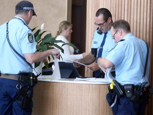 Police deal with the paperwork while checking in newly arrived travellers. Picture: Matrix Media Group