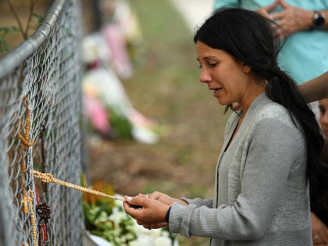 Leila Abdallah pauses near flowers placed at the scene where seven children were hit on a footpath by a four-wheel drive in the Sydney suburb of Oatland. Picture: Joel Carrett