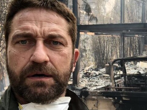 Gerard Butler stands in front of what remains of his house.