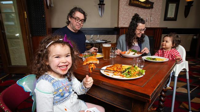 Olive Chapman, 4, is keen on a Parma now that she can get a Pub meal with sister Sloane, 18 months, and parents Josh Chapman and Kat O'Brien at the Auburn Hotel. Picture: Mark Stewart