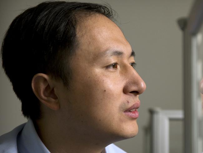 FILE - In this Oct. 10, 2018, file photo, He Jiankui is reflected in a glass panel as he works at a computer at a laboratory in Shenzhen in southern China's Guangdong province. A Chinese investigation says Chinese scientist He, behind the reported birth of two babies whose genes had been edited in hopes of making them resistant to the AIDS virus, acted on his own and will be punished for any violations of the law. (AP Photo/Mark Schiefelbein, File)