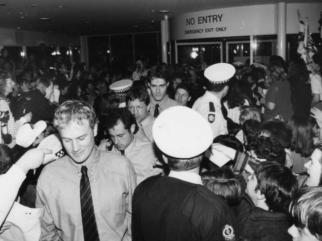 Nigel Smart, Tony McGuinness, Chris McDermott, David Pittman and Mark Bickley are greeted by a screaming crowd at Adelaide Airport after their elimination final win.