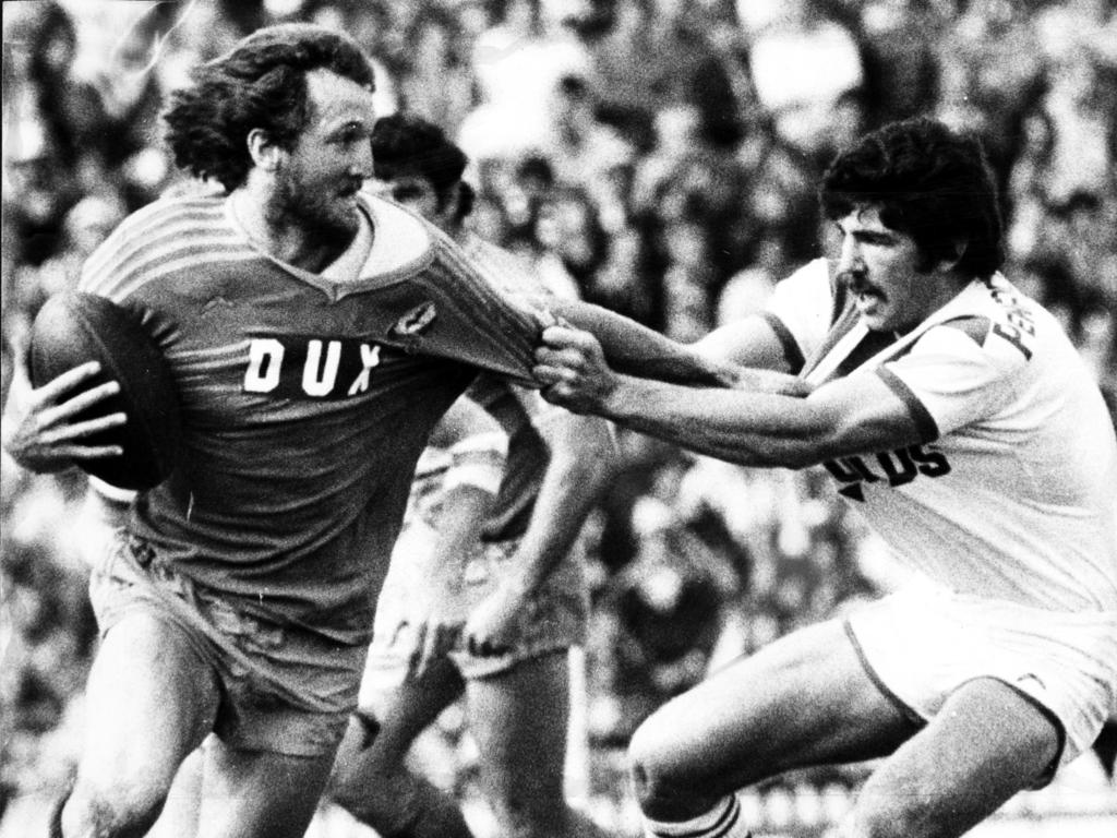 Rod Reddy (right) grabs Ray Price in the drawn 1977 grand final. Picture: Graeme Fletcher