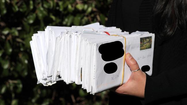 A woman with the stack of letters she received from her pen pal in prison. She later married him. Picture: Tim Hunter