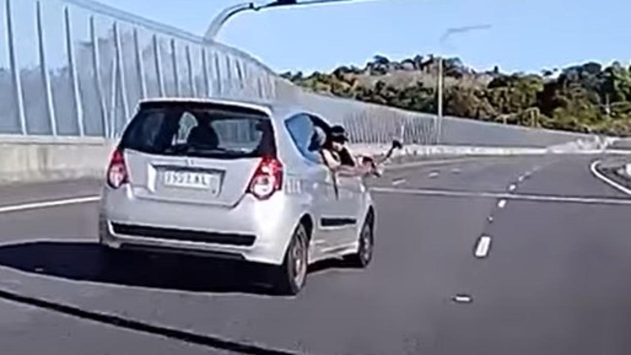 The man waves an axe as he passes the car. Picture: YouTube/ Dash Cam Owners Australia