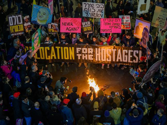 TEL AVIV, ISRAEL - FEBRUARY 08: Protestors chant and call for the ceasefire deal to continue while holding a banner that reads "relocation for the hostages" during an anti-government demonstration outside the Kirya on February 08, 2025 in Tel Aviv, Israel. Earlier today hostages Or Levy, Eli Sharabi, and Ohad Ben Ami were released, and appeared highly malnourished causing many to draw parallels to images from the Holocaust, which was a motif of tonight's protest. Protesters called on U.S. President Donald Trump to push Israeli Prime Minister Benjamin Netanyahu, who most no longer believe is doing what is best for the hostages,  to continue the current Israel-Hamas ceasefire agreement into its second phase. (Photo by Alexi J. Rosenfeld/Getty Images)