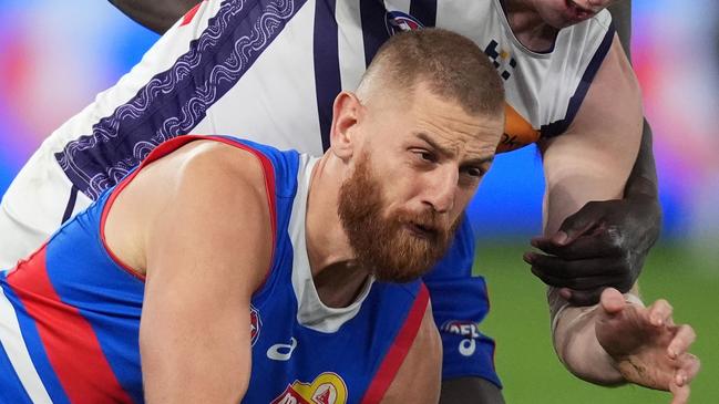 MELBOURNE, AUSTRALIA - JUNE 15: Liam Jones of the Bulldogs handballs under pressure from Josh Treacy of the Dockers during the round 14 AFL match between Western Bulldogs and Fremantle Dockers at Marvel Stadium, on June 15, 2024, in Melbourne, Australia. (Photo by Daniel Pockett/Getty Images)