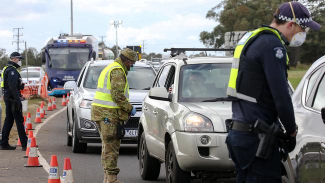 Victorian Police and Australian Defence Force personnel inspecting cars at a vehicle checkpoint on the Princes Highway at Little River near Geelong. Picture: NCA NewsWire / Ian Currie