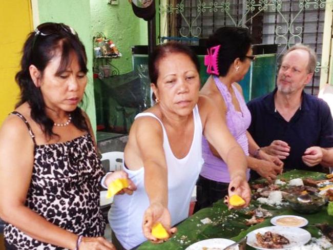 Las Vegas shooter Stephen Paddock (right, black shirt) sharing a meal with Marilou Danley's family in Manilla in 2013. Picture: Supplied