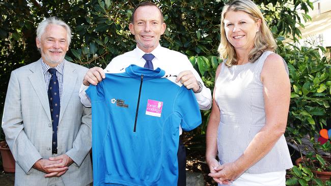 Tony Abbott receives a cycling jersey from Dr Michael Brydon and Nursing Manager Narelle Martin during a visit to Bear Cottage. Picture: Braden Fastier